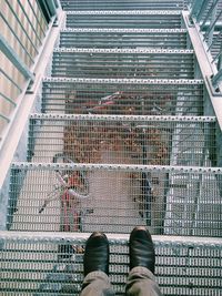 Low section of man standing on metal grate