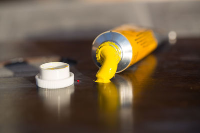 Close-up of yellow paint tube on table