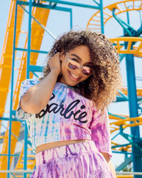 Low angle portrait of woman standing against ride