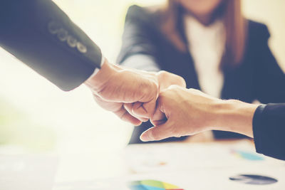 Business coworkers gesturing over graphs at desk in office