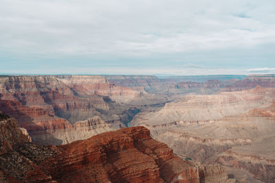 Scenic view of rock formations against cloudy sky