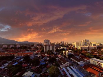 High angle view of city buildings against sky during sunset