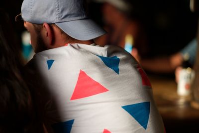 Rear view of man in cap sitting indoors