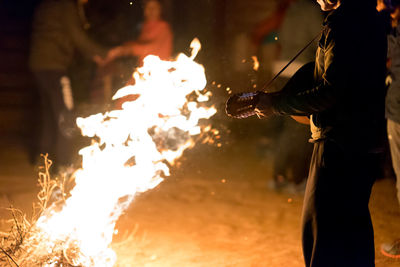 Low angle view of man holding bonfire at night