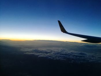 Airplane flying in sky during sunset