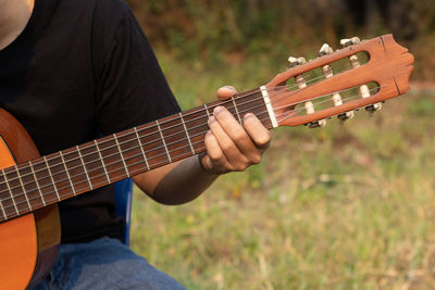 Midsection of man playing guitar