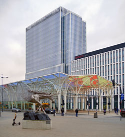 People in modern building against sky in city