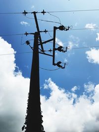 Low angle view of silhouette electricity pylon against sky