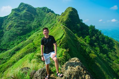 Full length of man standing on rocks against mountain