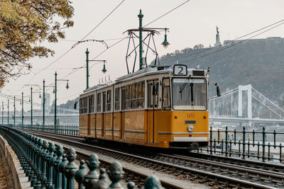 Yellow tram on tracks in street of budapest, hungary