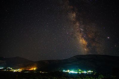 Scenic view of illuminated mountains against sky at night