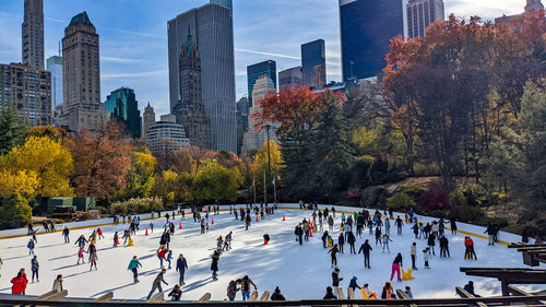Group of people ice skating at central park in new york city.