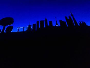 Silhouette of ferris wheel at night