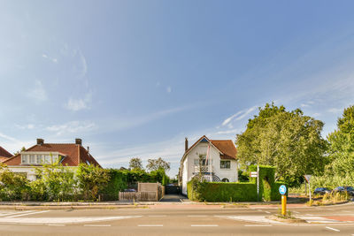 Houses by sea against sky