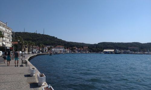 Scenic view of sea by town against clear blue sky