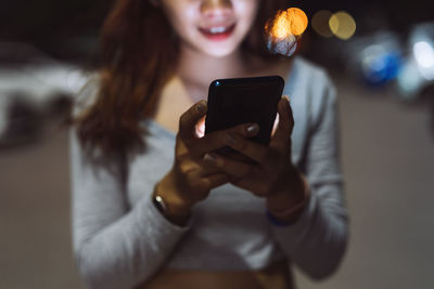 Midsection of woman using mobile phone