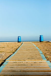 View of empty beach against clear blue sky