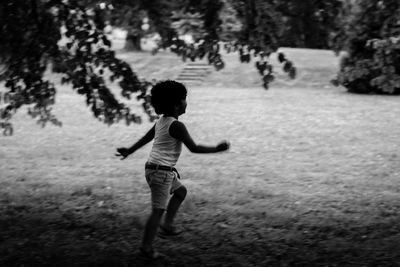 Boy running on field at park