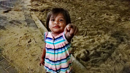 Portrait of cute girl standing on sand