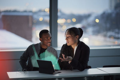 Two young business people working together in office