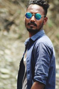 Portrait of young man wearing sunglasses standing outdoors