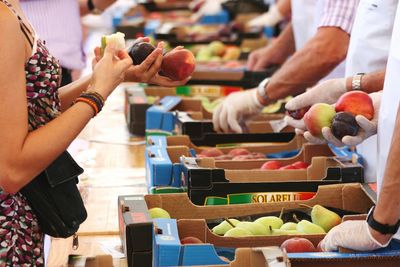 Midsection of woman purchasing fruits at market