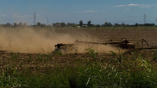 Side view of agricultural vehicle at work in field
