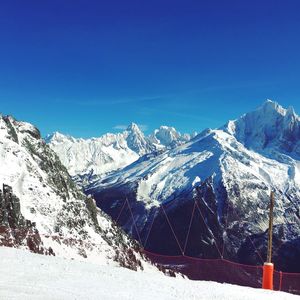 Scenic view of snowcapped mountains against clear blue sky