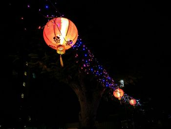 Low angle view of illuminated lanterns hanging at night