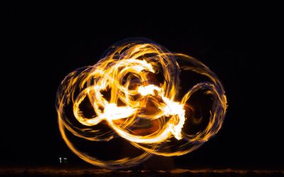 Man doing fire-twirling performance at night