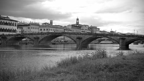 Arch bridge over river against sky