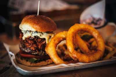 Close-up of burger and onion rings on table