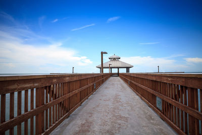 Low angle view of footpath against blue sky