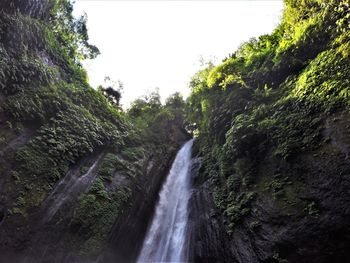 Scenic view of waterfall against sky