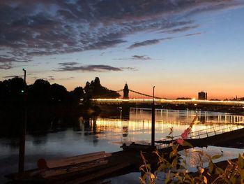 Bridge over river against sky during sunset