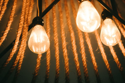 Low angle view of illuminated light bulbs