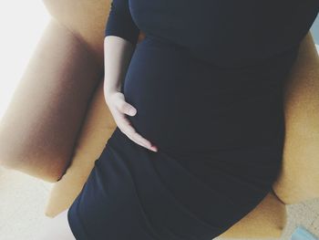 Midsection of woman standing by wall