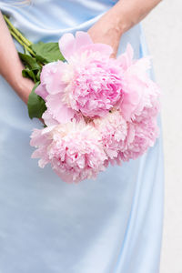 Bride in a blue wedding dress with a bouquet of pink peonies, pastel paradise