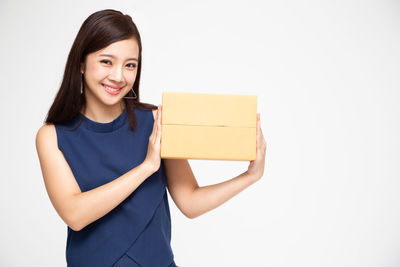 Portrait of a smiling young woman against white background