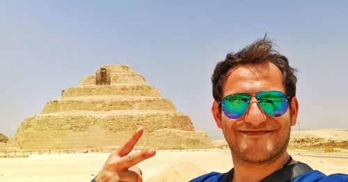 Portrait of man wearing sunglasses against sky