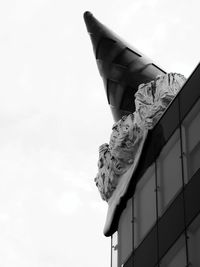 Low angle view of statue against building against sky