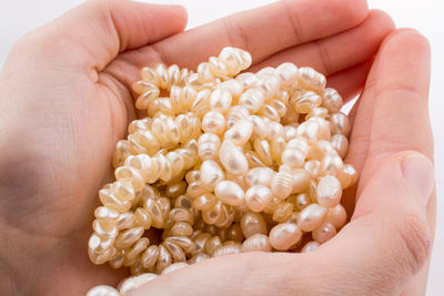 Close-up of cropped hands holding pearl jewelry