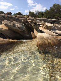 Rocks in sea against sky