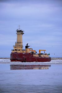 Scenic view of lake against sky tugboat breaking up the ice making a path 