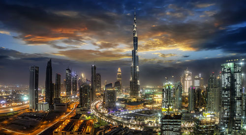 High angle view of illuminated buildings against cloudy sky