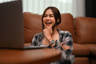 Young woman sitting on sofa at home