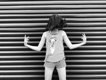 Girl standing against corrugated iron