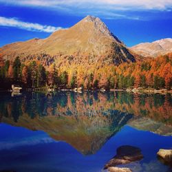 Scenic view of mountain with reflection in lake during autumn