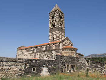 Low angle view of old building against clear blue sky