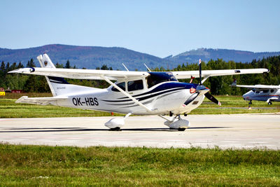 Airplane on airport runway against sky